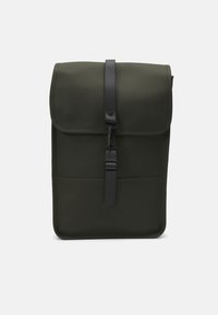 Olivgrön ryggsäck med matt yta, försedd med en vikbar klaff, svart stängningsrem och en minimalistisk design. Platt silhuett utan utsmyckningar.