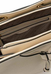 Borsa a mano in pelle beige con un esterno texturizzato, dotata di una tasca interna con cerniera e foderata in tessuto con un motivo sottile. Finiture in oro.