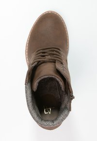 Brązowy botek za kostkę wykonany z eco-skórki, z sznurówkami i bocznym zamkiem błyskawicznym. Wnętrze wyłożone miękkim materiałem o wzorze w jodełkę.