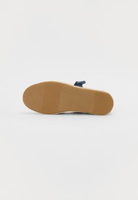 Sandal de marinha com sola de borracha plana, apresentando um design texturizado e antiderrapante, além de uma única fita para um ajuste seguro.