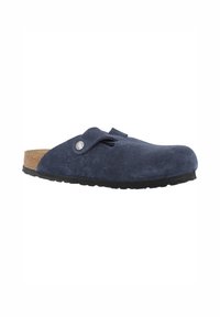 Zoccolo in suede blu navy con punta arrotondata, cinturino regolabile e dettagli in metallo argentato. Suola in sughero e gomma nera per comfort e durata.