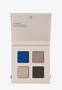 Palette de fards à paupières avec quatre teintes carrées : bleu métallique, taupe, beige clair irisé et gris charbon foncé dans un étui beige.