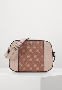 Beżowa torba na ramię z brązowym, wzorzystym przodem, ozdobiona akcentami z logo oraz odpinanym paskiem. Gładka faktura i usztywniony kształt.