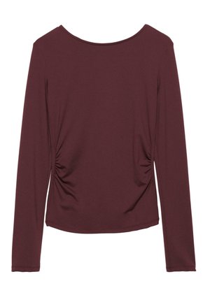 Duge dug madžuran majica dugih rukava od mekanog materijala, s bočnim naborima, okruglim izrezom i prilagođenim krojem. Glatka tekstura, bez vidljivih uzoraka.