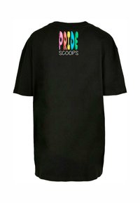 Svart t-skjorte med et fargerikt og lekent design på baksiden med ordene "PRIDE SCOOPS" i ulike pastellfarger og boblebokstaver.