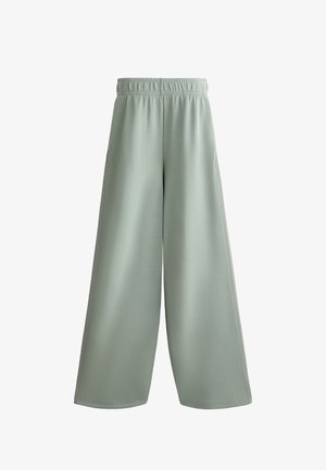 Hellegrüne weit geschnittene Hose aus weichem Stoff, mit einem dehnbaren Bund und zwei seitlichen Taschen, die eine glatte Textur und keine sichtbaren Muster aufweist.