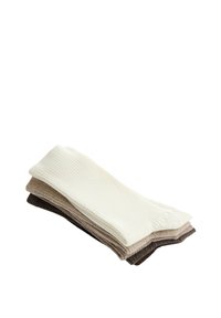 Trois paires de chaussettes côtelées empilées, en blanc, beige et marron foncé, sur fond blanc.