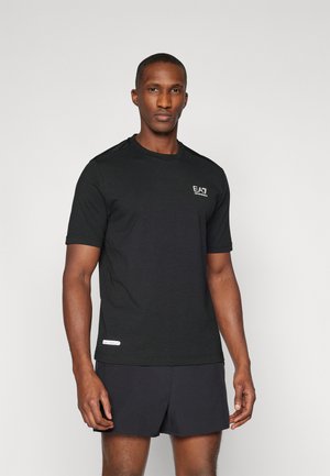 Svart kortärmad träningsskjorta i mjukt tyg, med en liten logotyp på bröstet och meshaccenter på axlarna, matchad med mörka shorts.