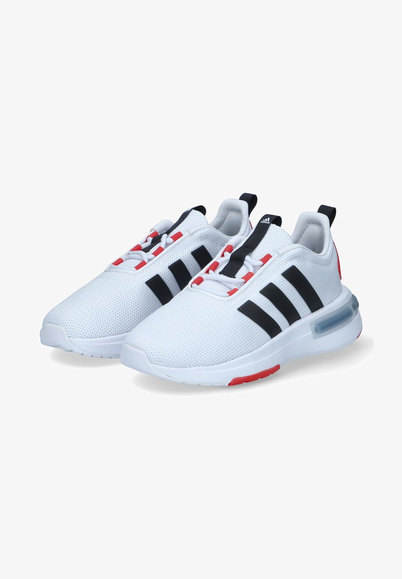 Zapatillas deportivas blancas con parte superior de malla, acentos negros y tres rayas negras. Presentan un tirador en el talón rojo y amortiguación de aire visible.