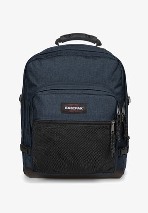 Mochila de tela azul marino con un bolsillo frontal de malla negra texturizada, doble cremallera y un asa resistente en la parte superior. Con el logo de Eastpak.