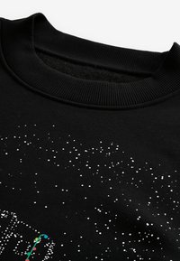 Felpa nera con collo tondo a coste. Presenta un motivo di punti bianchi sparsi che assomigliano a stelle, con un design colorato nella parte inferiore.