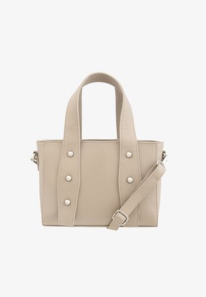 Beige leather handbag with two top handles, adjustable crossbody strap, and silver studs on the sides. Textured finish, rectangular shape.
