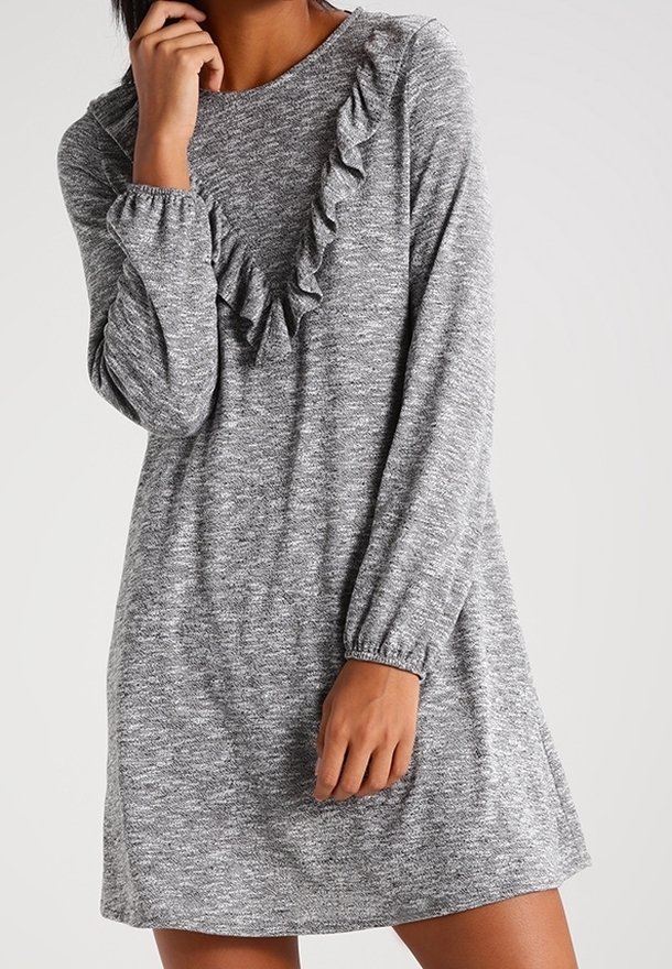 Šedé pletené šaty s dlouhými rukávy, volánkovým detailem na výstřihu, uvolněným střihem, jemnou texturou a mírnými rozparky na lemu.