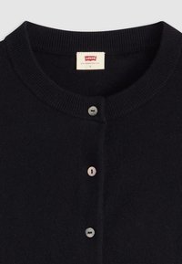 Zwart gebreid vest met een geribbelde kraag, voorzien van vijf knopen en een label met "Levi's," maat S. Zachte textuur en eenvoudig ontwerp.