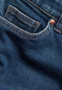 Jeans aus Denim in einem dunkelblauen Farbton, mit leichter Ausbleichung, einer kleinen Vorderasche und Details aus Kupferhardware/Knopf. Die Textur ist glatt mit sichtbaren Nähten.