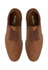 Chaussures en cuir marron avec une finition lisse, bout rond et laçage. Accents beige clair autour de la cheville, couture détaillée le long de la semelle.