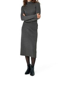 Grå ribbad stickad klänning med hög hals, långa ärmar och midilång kjol. Bärs med svarta ankelboots och transparenta strumpbyxor.