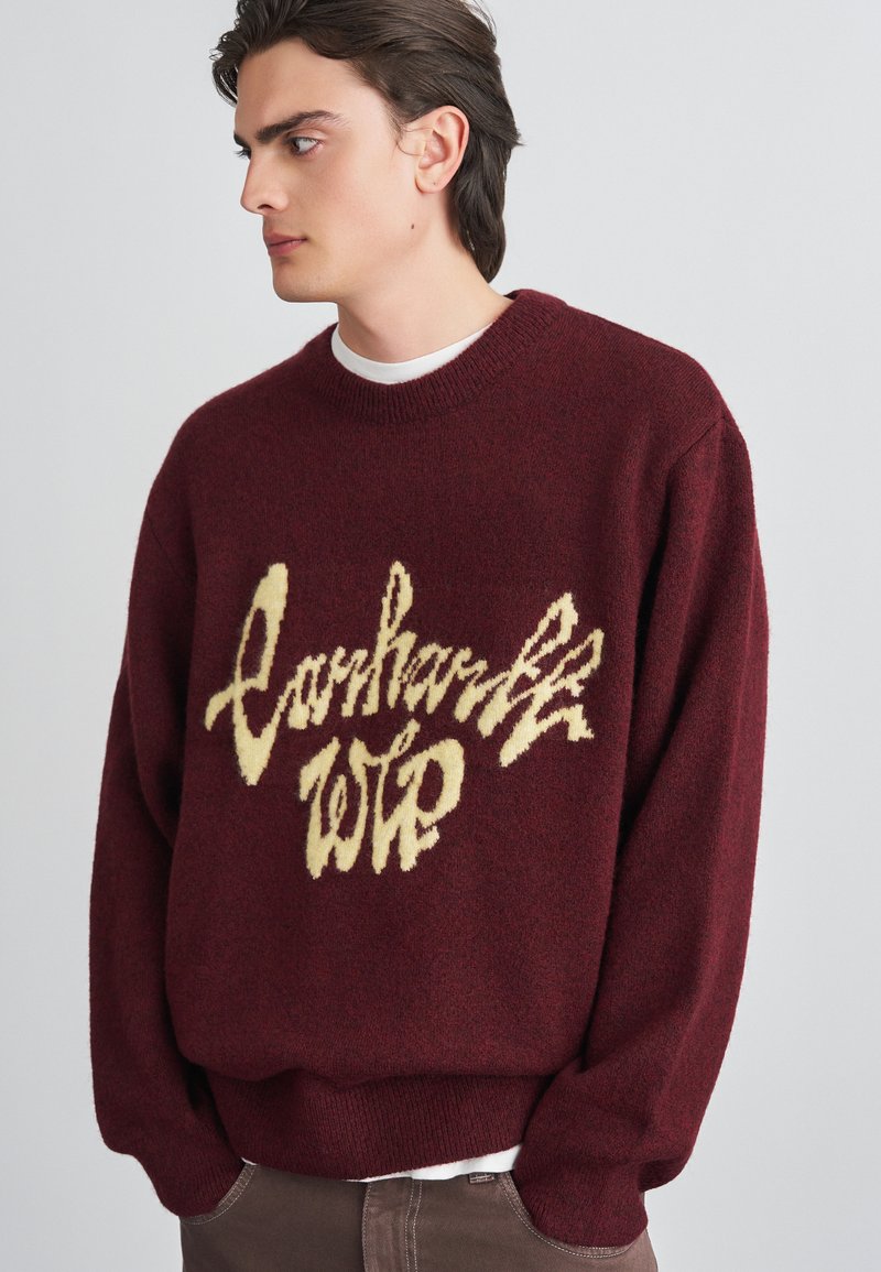 Bordeaux gebreide trui met een groot crèmekleurig logo-ontwerp, ronde hals, geribde manchetten en zoom, gemaakt van een gestructureerde wolmix.