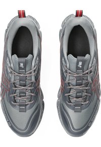 Scarpe sportive grigie con superiore testurizzato, dettagli rossi, particolari riflettenti e suola ammortizzata, dotate di chiusura con lacci.