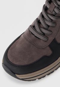 Høyt opp sneakers med en grå semsket skinnoverdel, svarte skinnakenter, teksturert lisser og en lagdelt såle med en beige stripe.