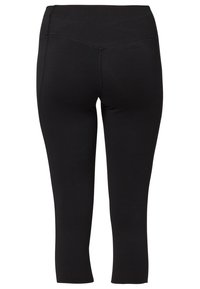 Leggings capri noirs, ajustés, avec une texture lisse, une large ceinture et des détails de couture minimaux. Ils arrivent mi-mollet.