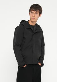 Schwarze, wasserdichte Jacke mit Kapuze, durchgehendem Reißverschluss, Seitentaschen und verstellbaren Bündchen. Glatte Textur und minimales Design.