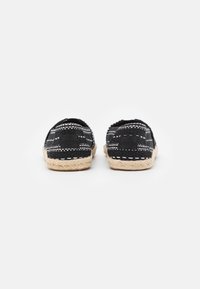 Espadrillas nere con motivo, dotate di parte superiore in tessuto e suola in corda di juta naturale, caratterizzate da un retro basso e dettagli di cucitura bianca.