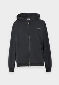 Sudadera con cremallera negra que cuenta con una tela suave, puños y dobladillo de canalé, bolsillo tipo canguro y un pequeño logo en el pecho. Ajuste regular.