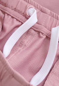 Roosa tekstuuriga kangas sujuva viimistlusega, millel on valge pael ja õmblemiseks detailid vöökoha lähedal.