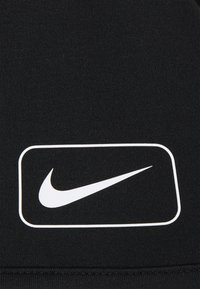 Musta kangas sileällä pinnalla, jossa on valkoinen Nike-logo suorakaiteen muotoisessa ääriviivassa. Suunnittelu on minimalistinen ja rohkea.