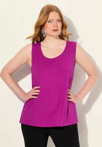 Top sin mangas fucsia con escote redondo, hecho de una tela suave. Presenta un corte relajado y se drapea suavemente en los laterales.