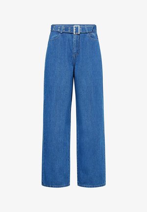 Svetlo modre kavbojke širokih hlačnic z pasom, ki ima srebrno zaponko in kovinske zatiče, narejene iz jeansa z gladko teksturo.