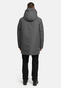 Grå vattentät parka med huood, med rak passform, dragkedjeslutning och långa ärmar. Bakifrån är det inga synliga mönster eller detaljer.