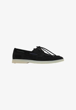 Sort ruskind loafers med hvid sål og snørebånd foran, vist fra siden på hvid baggrund.