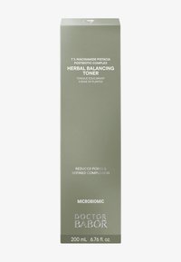 Toner équilibrant aux herbes dans une boîte rectangulaire, haute, de couleur vert olive mat. Présente du texte blanc et argenté détaillant les informations sur le produit et le volume.