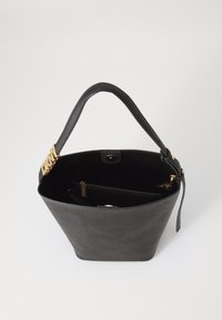 Black leather tote bag with a wide opening, gold hardware, and a zippered inner compartment. Smooth texture and structured shape.