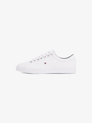 White leather sneakers with a smooth texture, round toe, flat sole, and silver eyelets. Features a small red, white, and blue logo on the side.