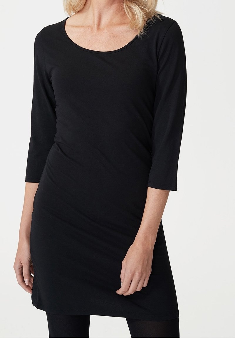 Černé šaty s dlouhým rukávem, s kulatým výstřihem, střih přiléhající na tělo a jemně hladká textura. Délka až do poloviny stehen. Jednoduchý design bez vzorů.