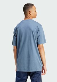 Niebieska bawełniana koszulka z krótkim rękawem, okrągłym dekoltem i luźnym krojem, charakteryzująca się gładką fakturą i minimalistycznym designem.