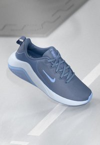Könnyű Nike sportcipő sötétkék színben, texturált hálós felsőrésszel, illeszkedő fűződizájnnal és kontrasztos fehér talppal valamint kiegészítőkkel.