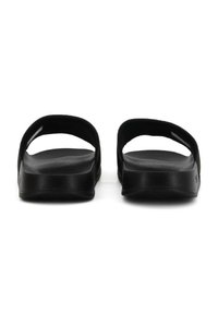 Sandali neri con due ampie cinghie, suole piatte e plantare testurizzato. Materiale liscio con design minimalista.