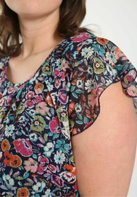 Blomsterbluse med mørk baggrund, korte bølgende ærmer, livfulde flerfarvede mønstre, letvægtsstof og en rynket hals detaljer.