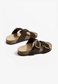 Barna velúr szandál két széles pánttal, aranyszínű csatokkal, párnázott talpbéléssel és tapadást biztosító texturált parafa talppal.