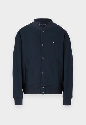 Marineblaue Bomberjacke mit Druckknopfverschluss, gerippten Bündchen und Saum, zwei Fronttaschen und kleinem Tommy Hilfiger-Logo auf der Brust.