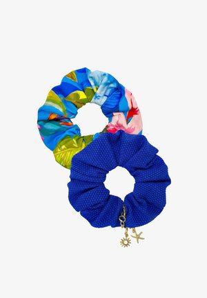 Dwa materiałowe scrunchie; jeden z tropikalnym kwiatowym wzorem w odcieniach niebieskiego i zielonego, drugi teksturowany w kolorze królewskiego błękitu z złotymi zawieszkami w kształcie słońca i rozgwiazdy.