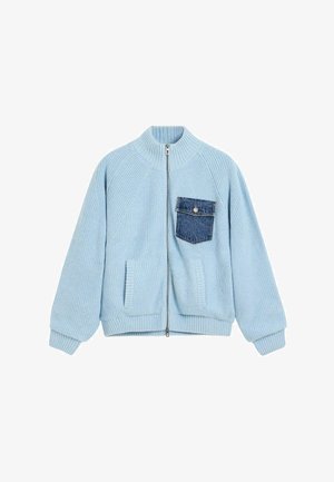 Pull zippé en tricot bleu clair avec poignets et taille côtelés, muni d'une poche poitrine en jean bleu foncé avec bouton.