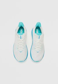 Baskets blanches de sport avec un dessus en mesh respirant, accents turquoise et lacets. Dotées d'une semelle rembourrée pour le confort et le soutien.