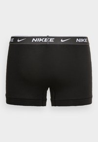 Boxeri negri Nike cu o talie contrastantă cu logo alb, având o textură netedă și un design până la mijlocul coapsei.