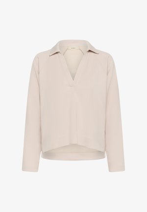 Svetlobéžový dlhý rukáv s golierom a hlbokým výstrihom do V, mierne skrátený spodný lem a voľný strih.