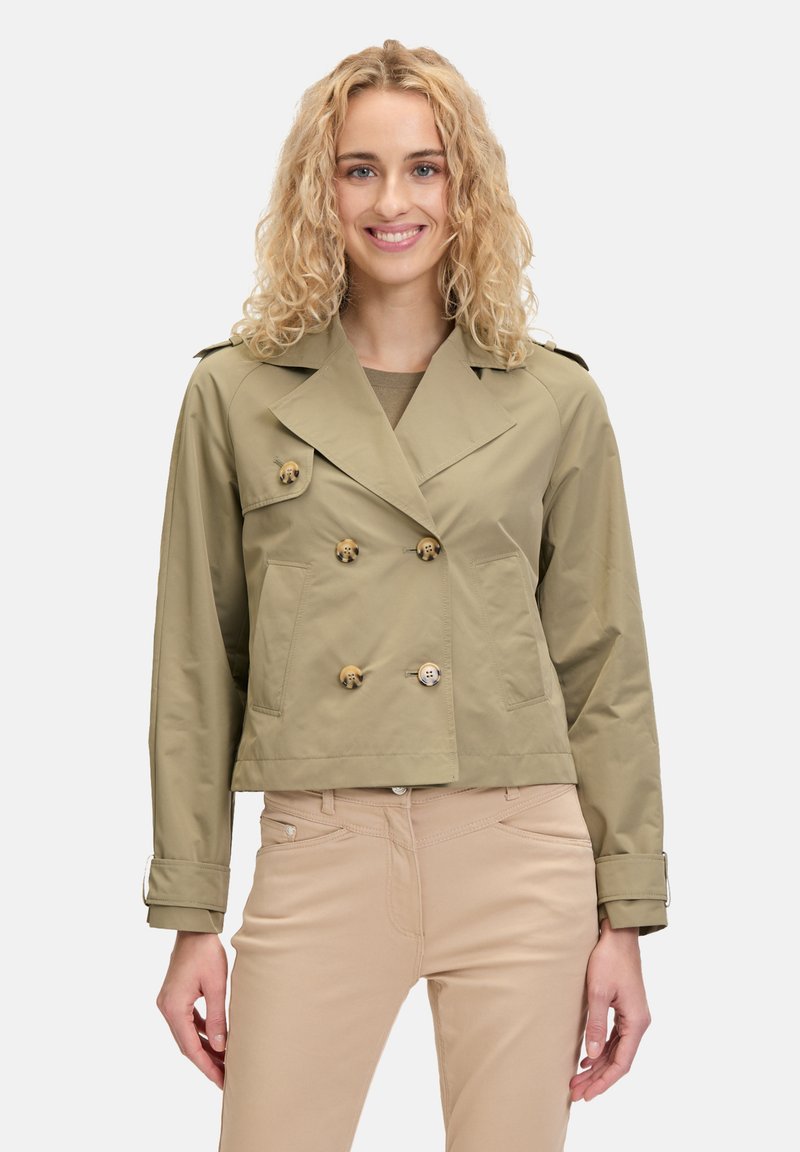 Kaki cropped trenchcoat met dubbelbreasted sluiting, grote knopen en zijzakken. Heeft een klassieke kraag en verstelbare mouwmanchetten.
